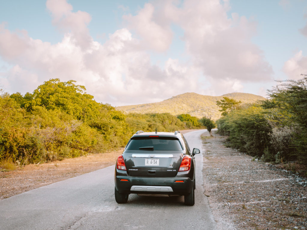 Car from car rental near beach in forest on Island Curaçao